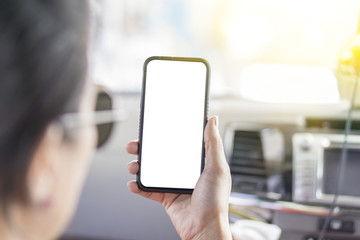 The middle-aged woman who wear sunglasses is touching mobile phone by forefinger while sitting on front seat in  car