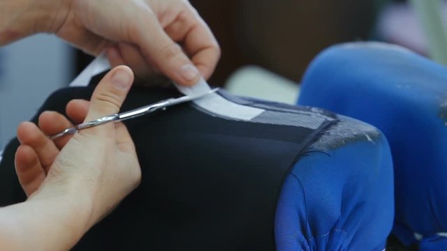 Thermal gluing of fabric by iron. Sewing of men's suits at the factory. Sewing clothes on professional equipment. Sewing clothes in the factory.