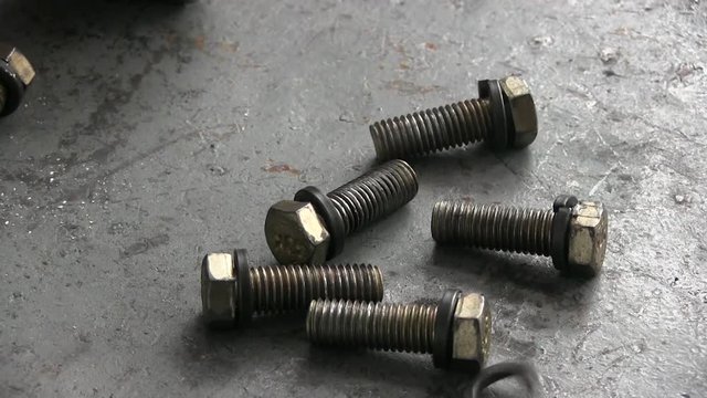 Metal shine screw nuts with internal thread and bolts. Mechanic worker tightening the screws on plant. Repair or engine assembly of equipment