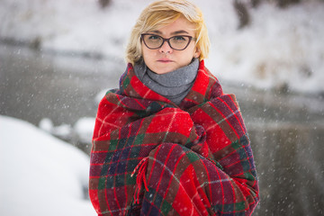 Soft portrait of odd lonely girl sitting in winter snowy forest. Friendless female person with sad emotional