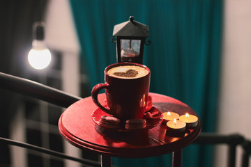 Cup of brewed coffee, a branch of spruce and lantern