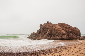 Coast, waves and beach with yellow sand and pebbles