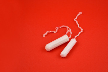 Women's tampons stock images. Feminine hygiene product. White tampons on a red background. Tampons for women