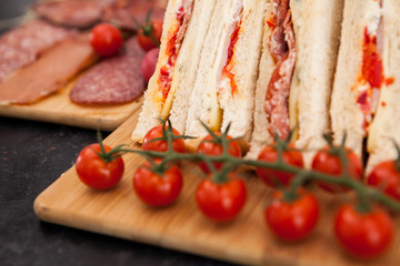 Appetizers and club sandwiches on wooden boards