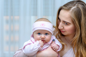 Mother holding her baby girl. Cute toddler portraits