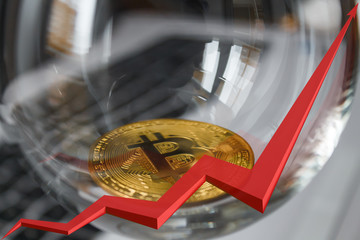 golden bitcoin on laptop background, red arrow is reflected in the glass