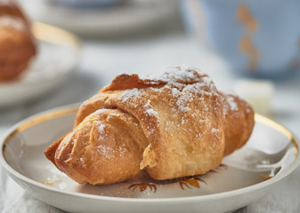 Croissants with jam on a plate and coffee on a white background.