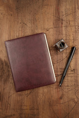 A leather bound journal, and ink well and pen