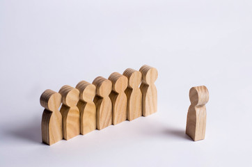 People stand in line at the briefing and wait for orders. Wooden figures of people are waiting in line. Concept of business, army, sports team. People listen to a mentor on a white background.