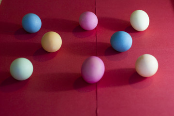 Fototapeta na wymiar Colorful eggs on a red backround