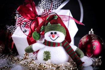 cute toy box snowman with gifts on a black background.