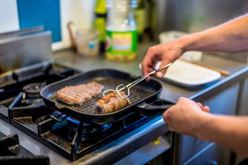 Close-up of chef's hands, meat baking