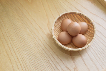 Eggs in a wooden basket on a wooden floor,background,food,copy space