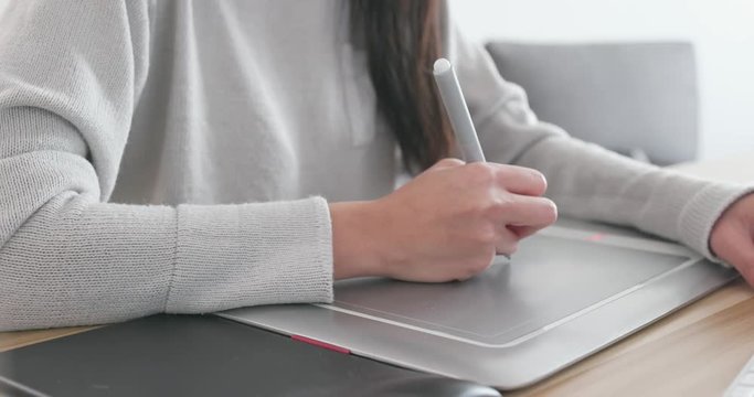 Designer working on computer and drawing pad