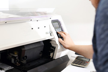 Maszyna drukarska. Pracownik obsługuje maszynę drukującą. - obrazy, fototapety, plakaty