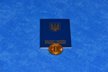 Crypto currency bitcoin lies on the passport of Ukraine on a blue background. The concept of business, mining, earnings in Ukraine.