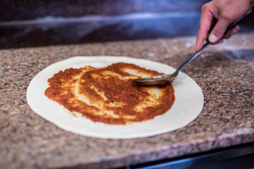 Close-up of chef's hands, pizza preparation