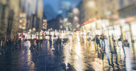 people walking on rainy night streets in the city