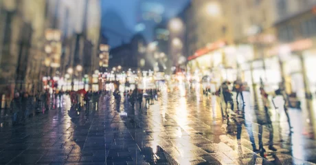 Rolgordijnen people walking on rainy night streets in the city © babaroga