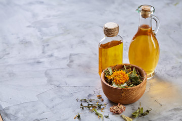 Spa still life with flowers in bowl and oil jars on light textured background, top view, close-up, selective focus