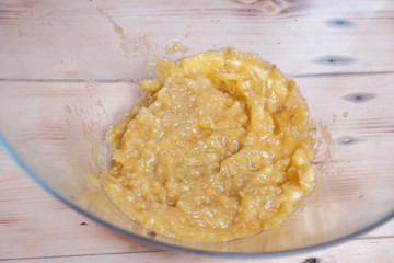 Young Asian boy mash the bananas in large bowl.