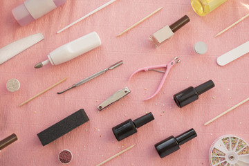 Pink background with set of equipment for gel nail manicure or pedicure.