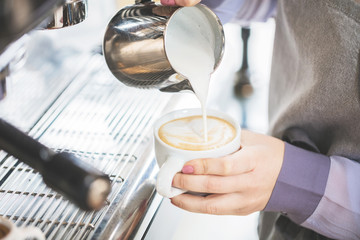 Barista bei der Cappuccino Zubereitung