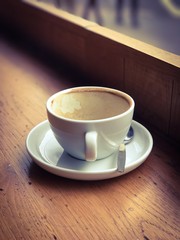 Empty coffee cup on the window side table.