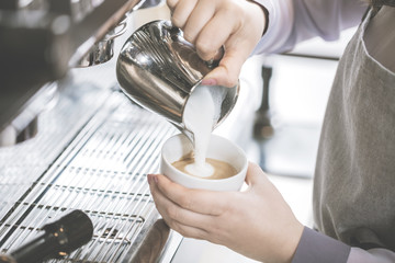 Barista bei der Cappuccino Zubereitung