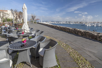 Maritime promenade with terrace bar in touristic and historic sardinian city of Alghero.