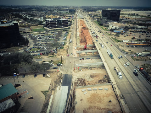 Aerial view construction of elevated highway in progress in Houston, Texas, USA. Workers and heavy machinery joining the various blocks, modules of the overpass line. Industrial background. Vintage