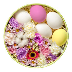 five multicolored and white easter eggs and flower bouguet with cotton box in the nest, isolated on white background