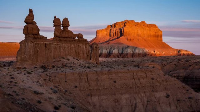 Time lapse of the sun lighting up Wild Horse Butte behind the Three Sisters in Goblin Valley Utah.