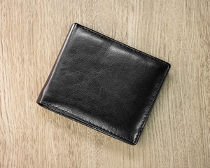 Black leather wallet  on wooden background. Top view of leather purse for keep your money.