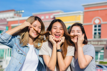 Happy young Asian women group city lifestyle playing and chatting each other among the pastel building city on weekend. City lifestyle of girls group. City lifestyle and outdoor activity concept.
