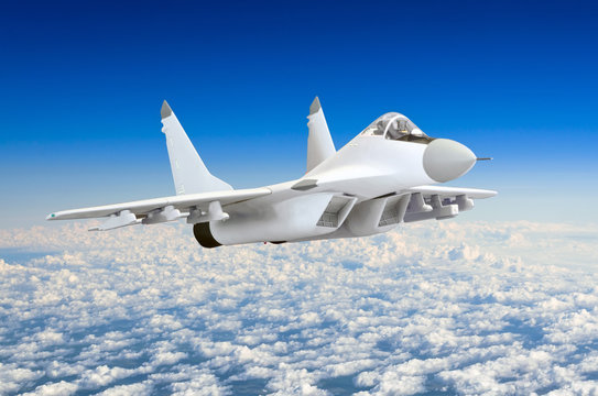 Military fighter aircraft at high speed, flying high in the dark blue sky.