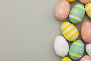 Easter holiday background. Pastel coloured decorated easter eggs on a grey background