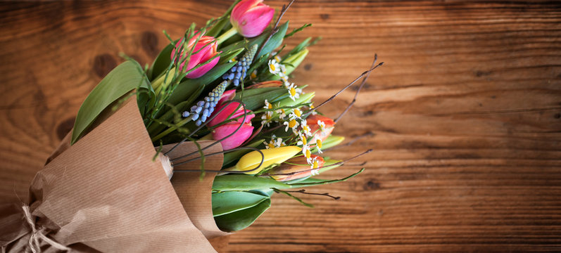 Colorful spring bouquet on dark rustic wood