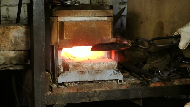 Making the knife out of metal at the forge. Heating of metal billets in the furnace.
