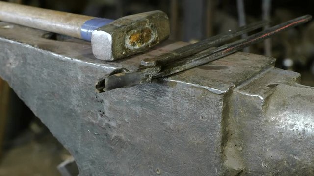 Hammer on anvil in the blacksmith's shop and clippers.