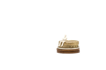 Miniature man sitting on top of British Pound Coin stack. On white background with space for text. Financial concept.