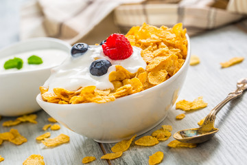 Cornflakes. Dish of cornflakes with yogurt blueberries and raspberries on kitchen table