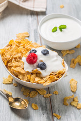 Cornflakes. Dish of cornflakes with yogurt blueberries and raspberries on kitchen table