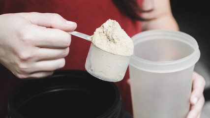 Going to pour casein protein powder into the cup. Fitness supplement food.
