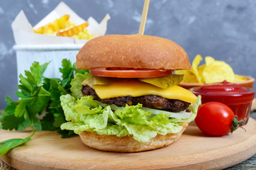 Burger, french fries, chips, sauce on a wooden background. Street food. Set of fast food products.