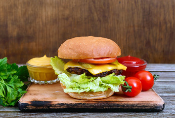 Juicy burger on a wooden background. Fast food. Street food.