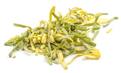 Fettuccine pasta classic and spinach pieces stack raw isolated on white background.