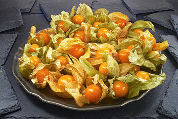 Physalis, egzotyczne owoce na czarnym tle (kamień łupkowy)