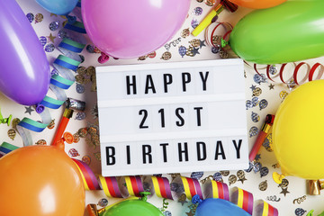 Happy 21st birthday celebration message on a lightbox with balloons and confetti