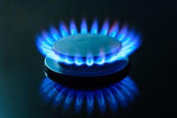 The gas is burning, the gas-stove burner, the hob in the kitchen, close-up. The concept of problems...